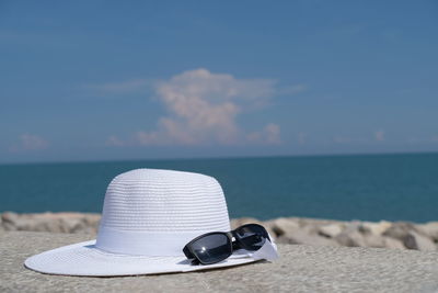 Women's summer white straw hat and sunglasses in front of the adriatic sea beach. 