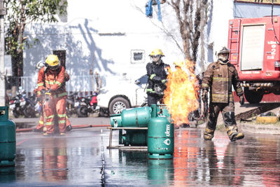 People on wet street in city