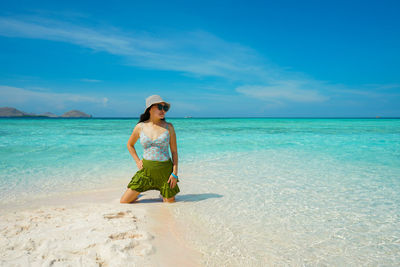 Rear view of woman standing at beach