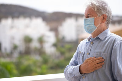 Close-up senior man wearing mask standing outdoors