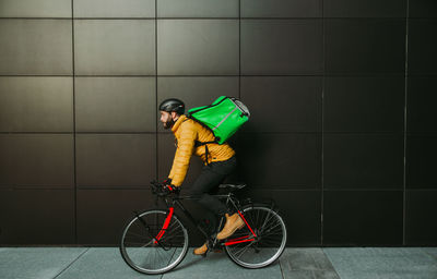 Man riding bicycle on street in city