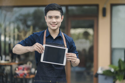 Portrait of smiling man holding smart phone