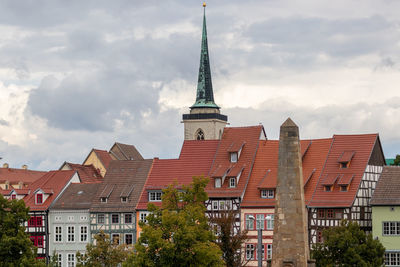 Buildings in city against cloudy sky