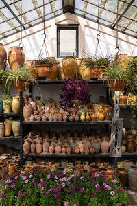 Many unique handmade colorful clay jugs and vases of various shapes on shelf in local market