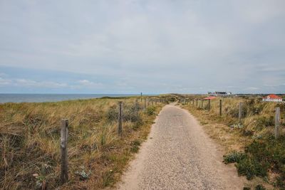 Road leading towards sea against sky