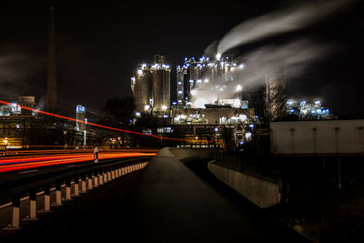 Illuminated bridge in city against sky at night