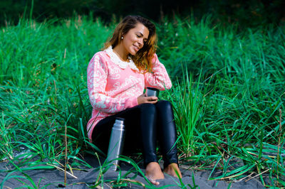 Portrait of smiling young woman sitting on grass