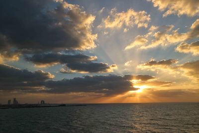 Scenic view of sea against dramatic sky during sunset