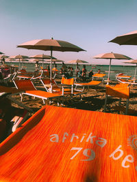Parasols on beach against clear sky