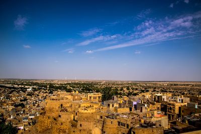 High angle shot of cityscape against blue sky