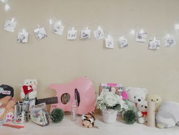 Various toys on table against wall