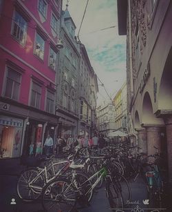 Bicycles parked on street amidst buildings in city