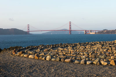 Suspension bridge over sea against sky