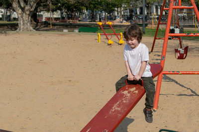 Full length of boy swinging at playground