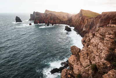 Rocks by sea against sky