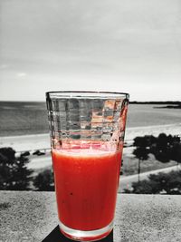 Close-up of red juice in sea against sky