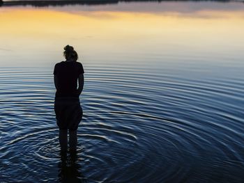 Rear view of man standing in lake