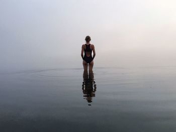 Young man standing in lake