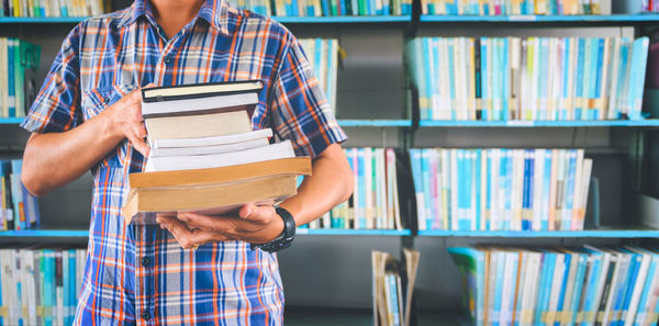 Midsection of man reading book