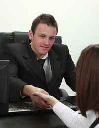 Businessman and businesswoman shaking hands in the office.