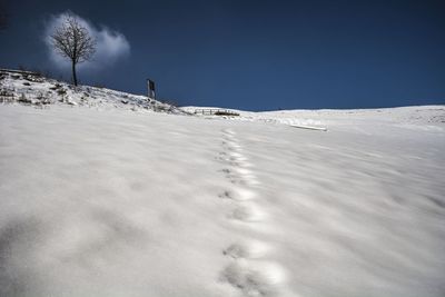 Snow covered landscape against sky