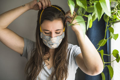 Woman indoors at home with homemade face mask protection ppe