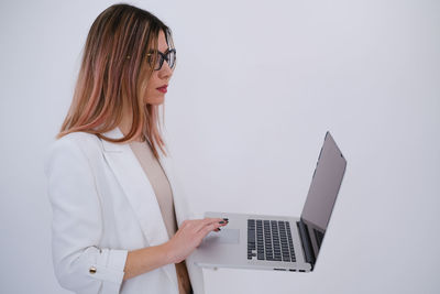 Young woman using laptop against white background