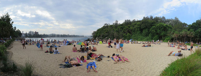 People at beach against sky