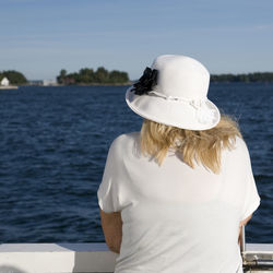 Rear view of woman standing by sea against sky