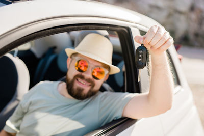 Low angle view of young woman sitting in car