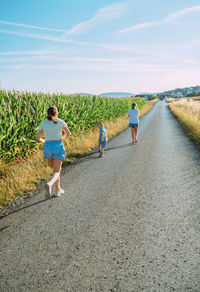 Rear view of woman walking on road