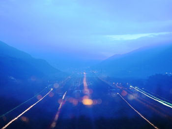 High angle view of illuminated city against sky at dusk