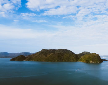 Scenic view of sea and mountains against sky