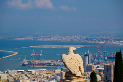 Statue of city against cloudy sky