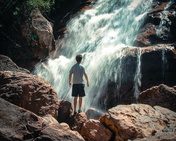 Rear view of man standing on rock