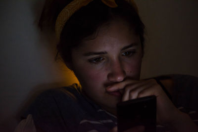 Close-up of young woman using mobile phone at home