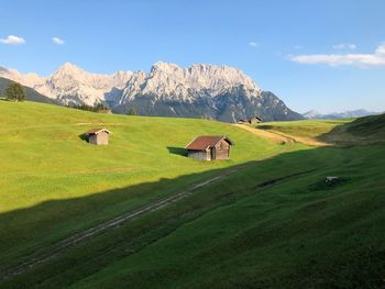 Scenic view of green landscape and mountains against sky