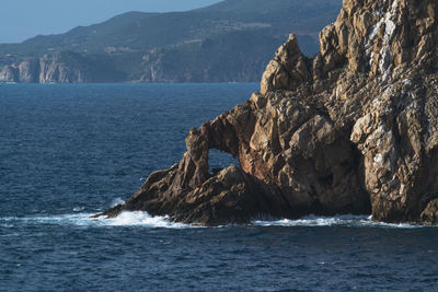 Scenic view of sea and mountains against sky