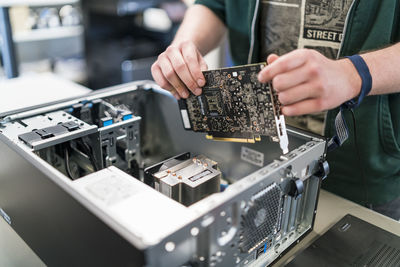 Close-up of teenager assembling personal computer