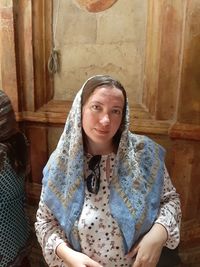 Portrait of mature woman wearing headscarf while standing in church