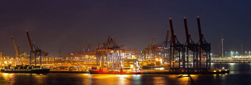 Sailboats in harbor against sky at night