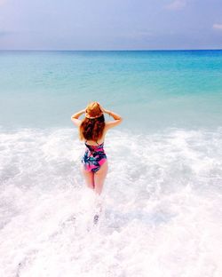 Rear view of woman walking on beach