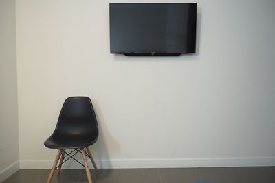 Empty chair on table against wall