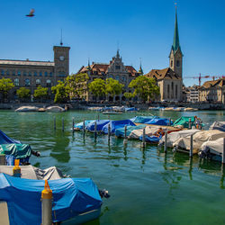 Boats in canal amidst buildings in city