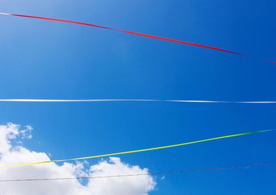 Low angle view of power lines against blue sky