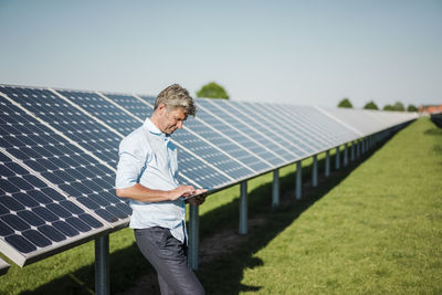 Businessman using tablet at solar park