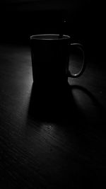 Close-up of coffee cup on table against black background