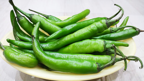 Close-up of green chili peppers in basket on table