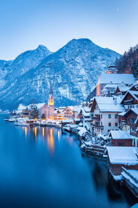 Ship in lake by townscape against sky