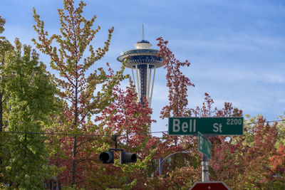 Autumn in seattle with the space needle peeking through colorful fall leaves.